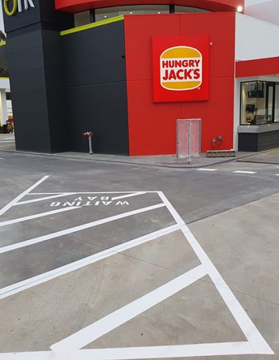 A newly marked Hungry Jacks drive thru, waiting bay and carpark with directional arrows.